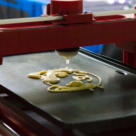 Ein 3D-Drucker druckt flüssigen Teig auf ein Blech.
