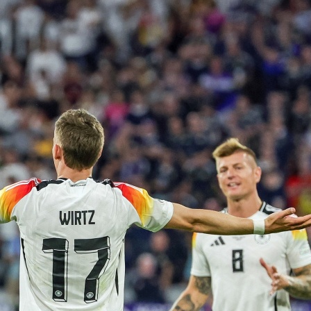 Der deutsche Fußball-Nationalspieler Florian Wirtz (l.) bejubelt sein Tor im EM-Eröffnungsspiel gegen Schottland. Toni Kroos läuft auf Wirtz zu, um ihm zu gratulieren.