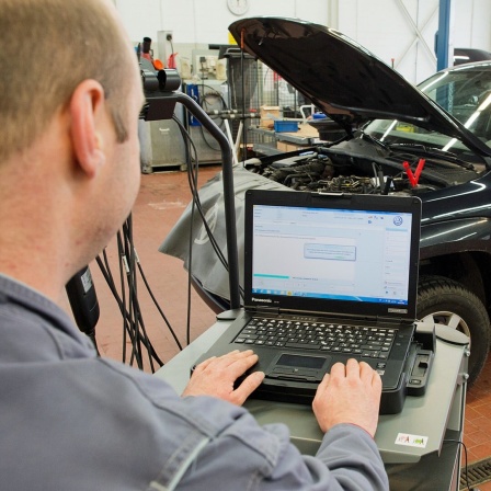 Ein Kfz-Mechaniker lädt ein Software-Update für das Steuergerät Motorelektronik auf einen Volkswagen Amarok mit einem 2,0-Liter-Dieselmotor.