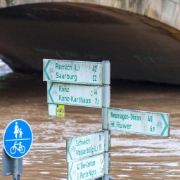 Radwegeschilder stehen am Zurlaubener Ufer im Moselhochwasser. Für Trier hatte der Deutsche Wetterdienst am 18. Mai 2024 die höchste Warnstufe vergeben.