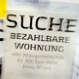 Eine Suchanzeige für eine bezahlbare Wohnung hängt an einem Schwarzen Brett 