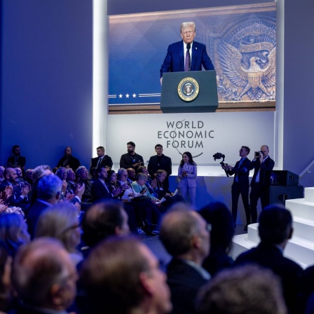 Beim Weltwirtschaftsforum in Davos 2025 ist auf einer Leinwand vor Publikum Donald Trump zu sehen, der per Videokonferenz zugeschaltet ist