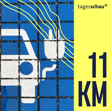 Auf einem Boden ist ein Logo für ein Elektroauto gemalt. 