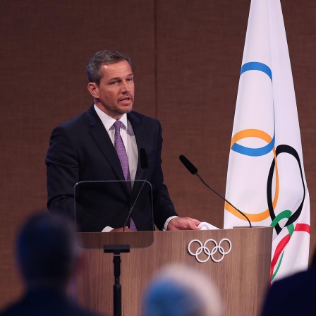 IOC-Mitglied Michael Mronz spricht vor einer IOC-Flagge bei der IOC-Sitzung im indischen Mumbai.