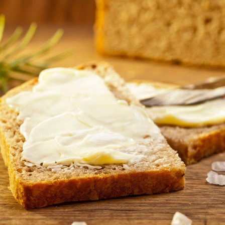 Frisches Brot mit Butter, Meersalz und einem Rosmarinzweig