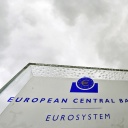 Eine Schild mit der Aufschrift "European Central Bank - Eurosystem" ist vor der Europäischen Zentralbank (EZB) in Frankfurt am Main (Hessen) zu sehen.