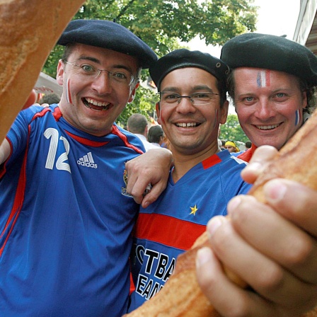 Französische Fußballfans posieren mit Baguettes