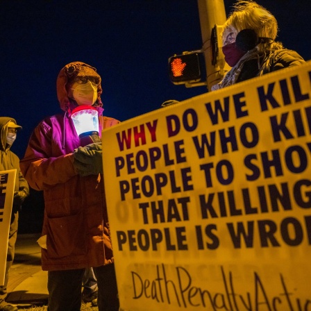 Glenda Breeden (M) aus Bloomington, Aktivistin gegen die Todesstrafe, hält eine Lampe, bei einem Protest gegen die Hinrichtung von Lisa Montgomery und zwei weiteren Personen im Gefängnis in Terre Haute im US-Bundesstaat Indiana. Die Regierung des abgewählten US-Präsidenten Trump hat eine wegen Mordes verurteilte Frau hinrichten lassen.