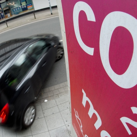 Ein Auto fährt an einem Schild mit Aufschrift "CO2" vorbei.