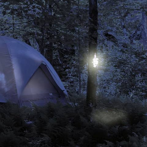Neben einem Zelt hängen Lichte an Bäumen