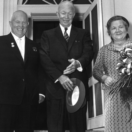 Der sowjetische Ministerpräsident Nikita Chruschtschow (l) wird kurz nach seiner Ankunft im September 1959 in Washington von dem US-amerikanischen Präsidenten Dwight D. Eisenhower (M) auf der Treppe von Blair House, dem Gästehaus der US-Regierung, begrüßt. Rechts Chruschtschows Frau Nina.