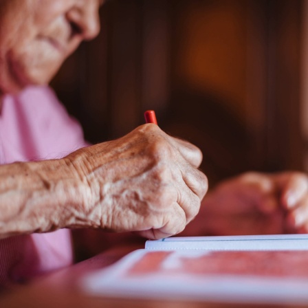 Nahaufnahme der Hand einer älteren Frau beim Zeichnen