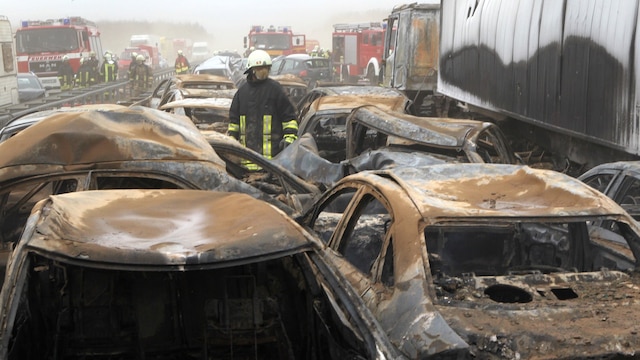 Feuerwehrleute sind am 8.4.2011 auf der A19 nahe Rostock bei einer Massenkarambolage im Einsatz. Bei einem Sandsturm sind Dutzende Fahrzeuge und Lkw ineinander gefahren und teilweise ausgebrannt.