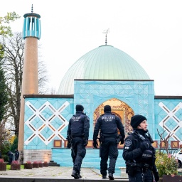 Einsatzkräfte der Polizei stehen während einer Razzia beim islamischen Zentrum Hamburg vor der Imam Ali Moschee (Blaue Moschee) an der Außenalster.