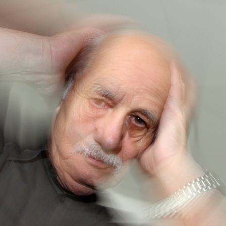 Ein älterer Mann fasst sich an seinen Kopf: Rund 30 Prozent aller Menschen in Deutschland erleben irgendwann in ihrem Leben Schwindel, auch Vertigo genannt, egal, wie alt sie sind.