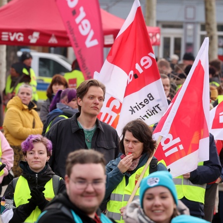 Teilnehmer einer Verdi Demonstration stehen auf dem Theaterplatz in Erfurt