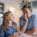 Eine Tochter spicht mit ihrem Vater in der Küche