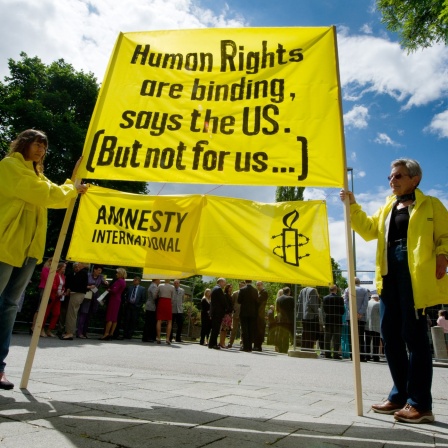 Mitglieder von AMnesty International halten ein Banner mit der Aufschrift "Human Rights are binding, says the U.S. (but not for us...)"