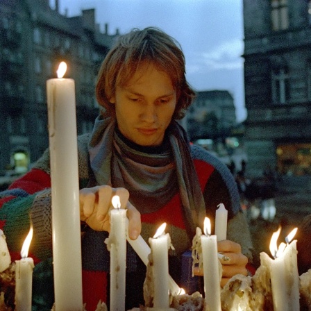 13.10.1989, Berlin, DDR - Junger Mann entzuendet Kerzen vor der Ost-Berliner Gethsemanekirche