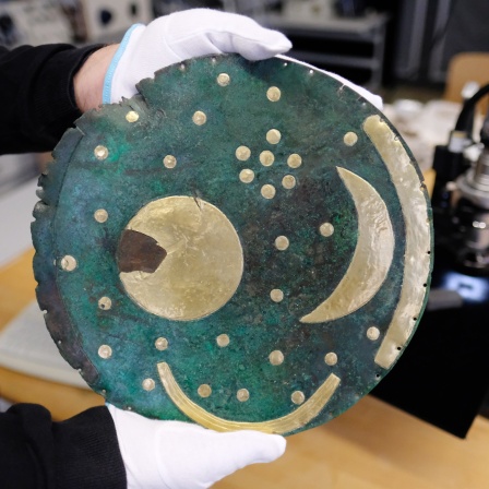 Ein Wissenschaftler hält in einem Labor des Landesamtes für Archäologe und Denkmalpflege Sachsen-Anhalt die Himmelsscheibe von Nebra.