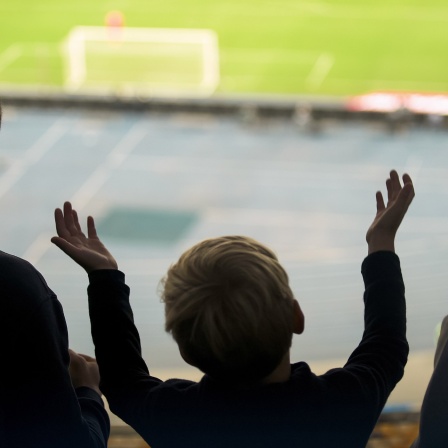 Ein Junge wirft bei einem Fußballspiel enttäuscht die Arme in die Luft. 