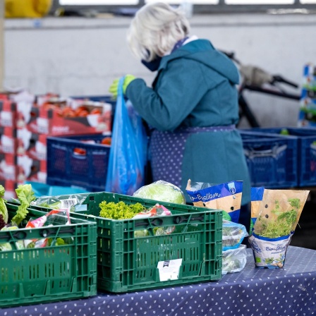 Ehrenamtliche Helfer der Münchner Tafel sortieren an der Ausgabestelle am Großmarkt Lebensmittel für die Gäste.