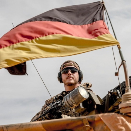Ein Soldat der Bundeswehr steht am Flughafen nahe des Stützpunkt in Gao im Norden Malis neben seinem Maschinengewehr.