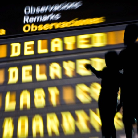 Anzeigetafel in einem Flughafen zeigt Verspätungen an.