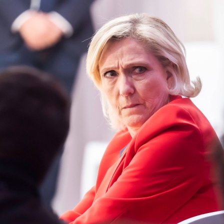 Die französische Rechtspopulistin Marine Le Pen sitzt auf einem Stuhl während einer Pressekonferenz