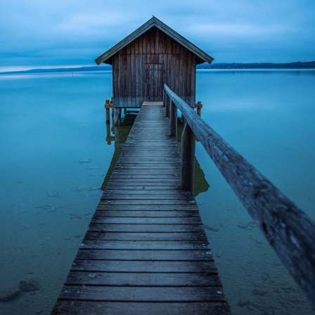 Bootshaus an See in romantischer Landschaft