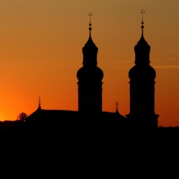 Neben den Türmen am Münster "Sankt Peter und Paul" in geht am Morgen die Sonne auf.