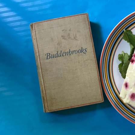 Ein Exemplar von Thomas Manns "Buddenbrooks" und Plettenpudding auf einem Tisch - Podcast "eat.READ.sleep" (Folge 7)