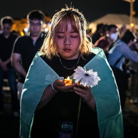 Menschen halten elektrische Kerzen, während sie an einer Mahnwache zum 35. Jahrestag des Tiananmen-Massakers von 1989 teilnehmen.