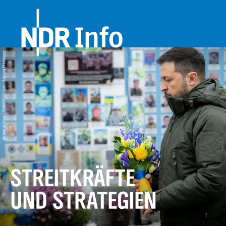 Der ukrainische Präsident Wolodymyr Selenskyj steht für eine Schweigeminute, bevor er Blumen an der Mauer zum Gedenken an die gefallenen Verteidiger der Ukraine auf dem Mykhailivska-Platz niederlegt.