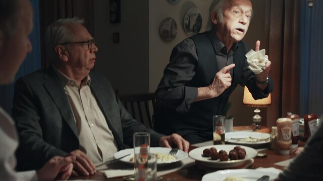Zwei ältere Männer an einem gedeckten Tisch.