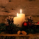 Zweiter Advent: Zwei Kerzen brennen auf einem rustikalen Holztisch mit Weihnachtsdekoration