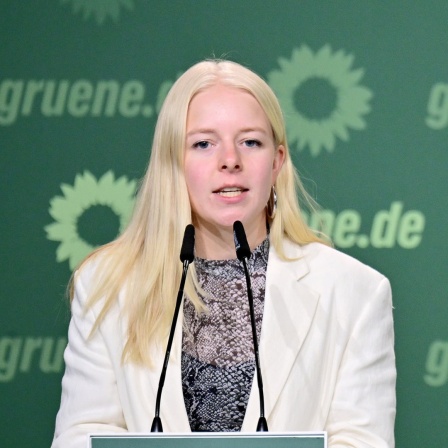 Die Bundessprecherin der Grünen Jugend, Jette Nietzard, bei einer Rede auf einem Podium.
