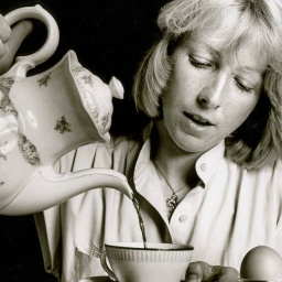 Junges Mädchen gießt aus einer Blümchenkanne Kaffee in eine Tasse, 1983