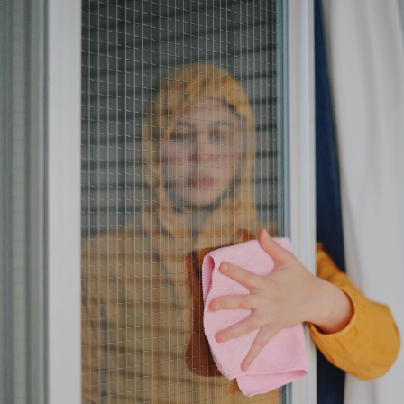 Portrait einer Fenster putzenden Frau.