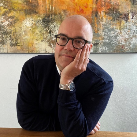 Portrait von Jens Kersten, er stützt den Kopf in die Hand.
