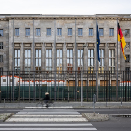 Fußgänger und ein Fahrradfahrer sind vor dem Finanzministerium in Berlin unterwegs (Bild: dpa / Hannes P. Albert)