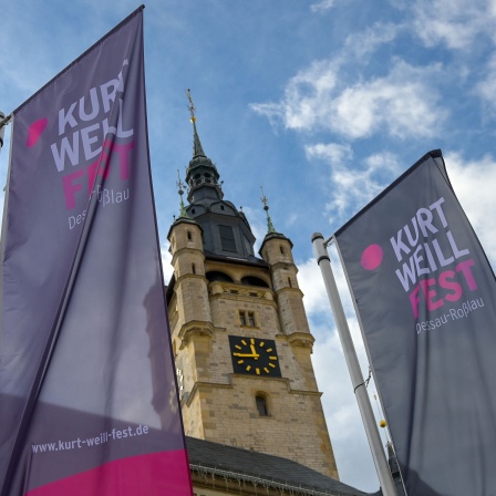 Vor dem Dessauer Rathaus wehen 2022 Fahnen des Kurt Weill Fest im Wind. 