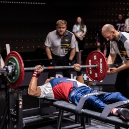 Ein Teilnehmer aus den USA, von der Hüfte abwärts gelähmt, beim Bankdrücken der 6. Invictus Games. Die Teilnehmer müssen dabei eine Hantelstange mit Gewichten in die Höhe stemmen. 