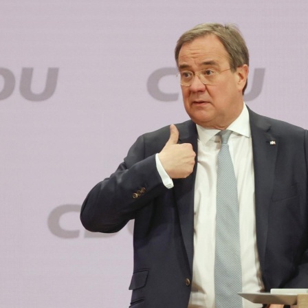 Armin Laschet steht vor dem Rednerpult beim CDU-Parteitag und hebt den Daumen seiner rechten Hand.