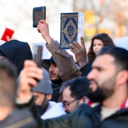 Teilnehmer einer Demo in Hamburg 2023 halten den Koran in die Höhe.