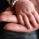 Eine Frau hält die Hand eines Babys