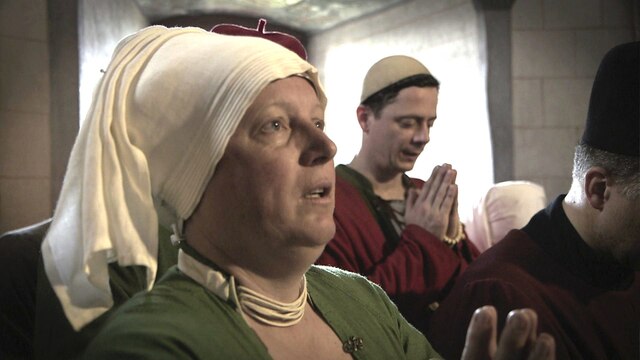 Menschn in mittelalterlichen Gewändern heben betend die Hände