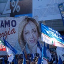 Anhänger der Partei Fratelli d'Italia halten ein Plakat mit einem Porträt von Parteichefin Giorgia Meloni in die Höhe. 