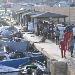 Boote und Migranten im Hafen von Lampedusa