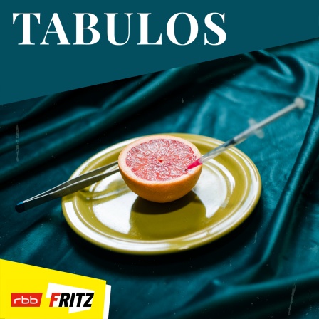 Eine Grapefruit auf einem Teller in der eine Spritze steckt, dahinter ein Pinzette (Bildquelle: Fritz | Lilly Extra)